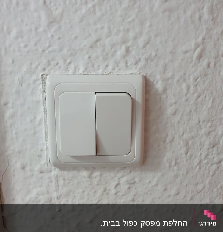 מתג חשמל לבן על קיר טיח
